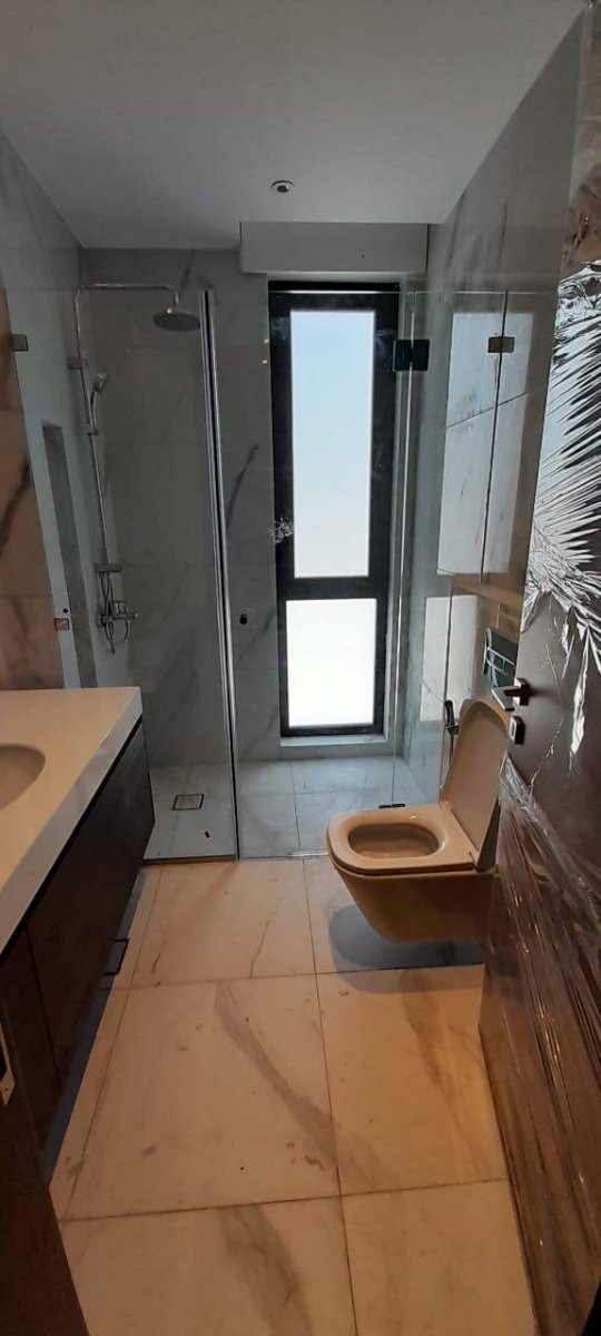 Glass shower door in marble bathroom