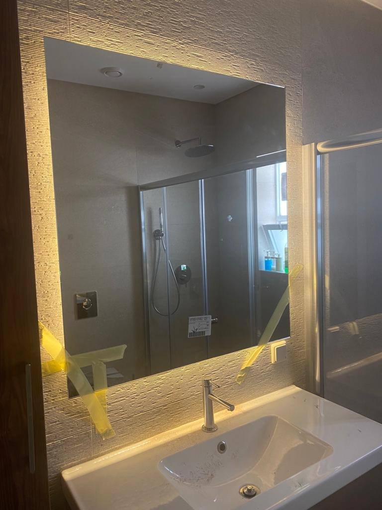 Backlit bathroom mirror installation