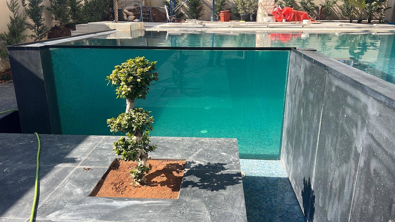Mansour Glass pool installation with crystal clear glass wall